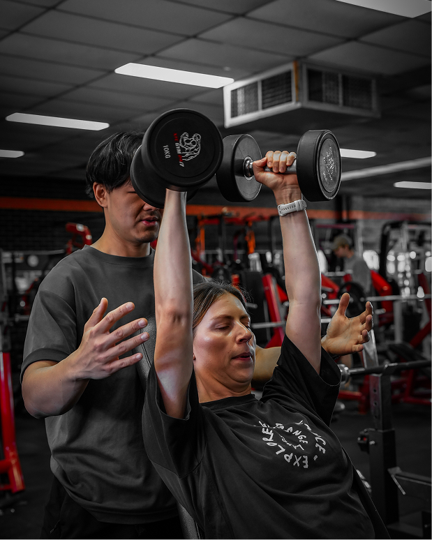 Coaching dumbbell press in gym